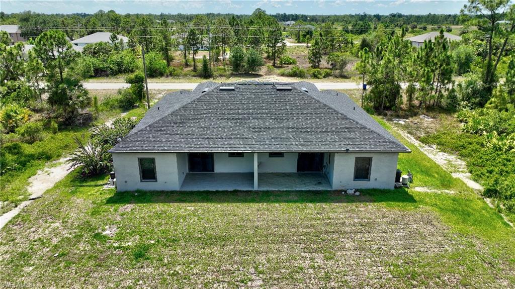 Aerial view of property and surrounding area with a tree filled landscape