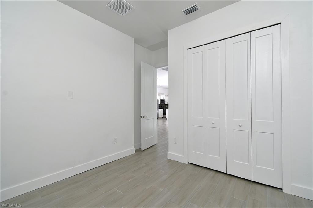 Unfurnished bedroom with light wood-style flooring and a closet