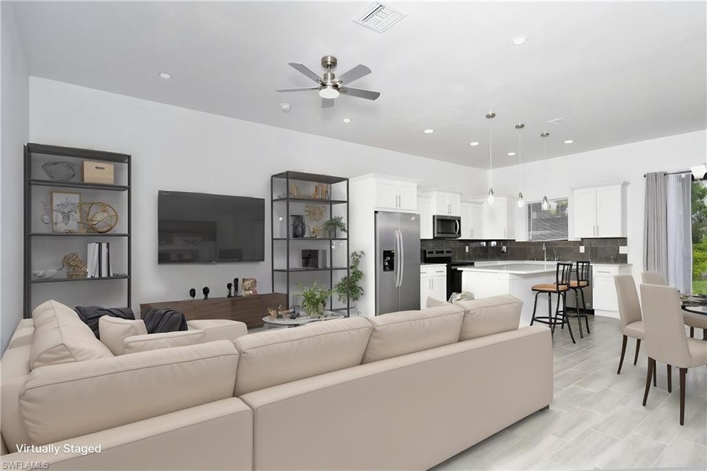 Living room featuring a ceiling fan and recessed lighting