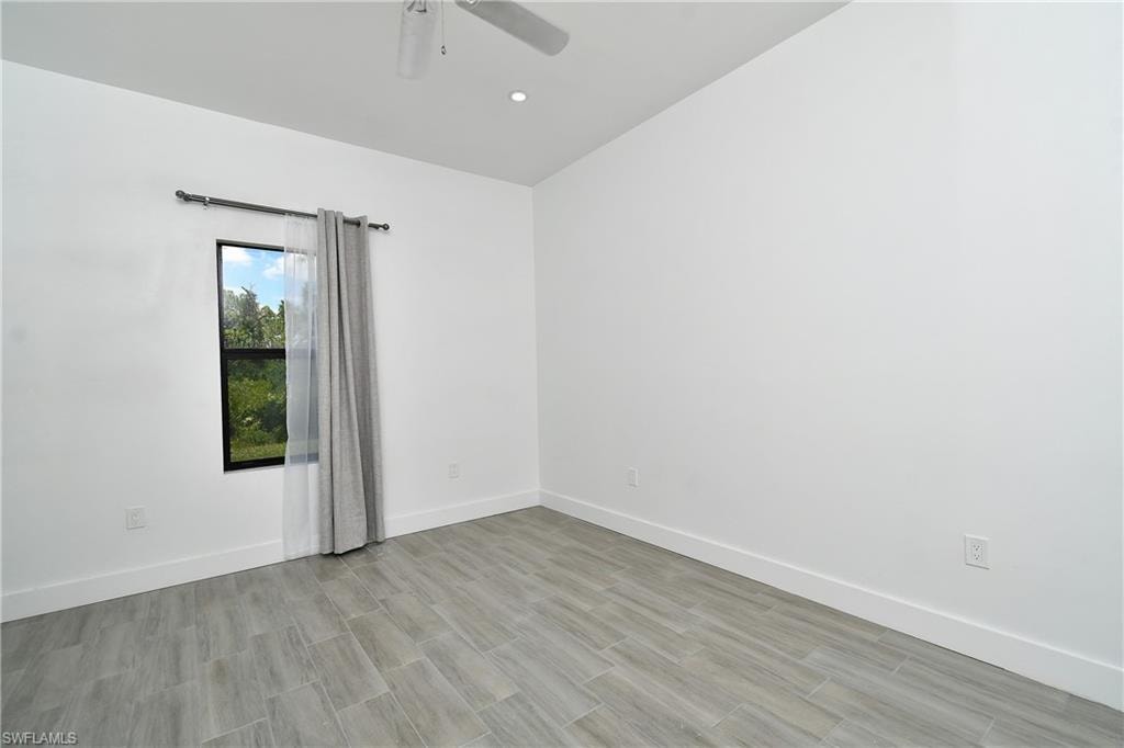 Spare room featuring wood finish floors and a ceiling fan