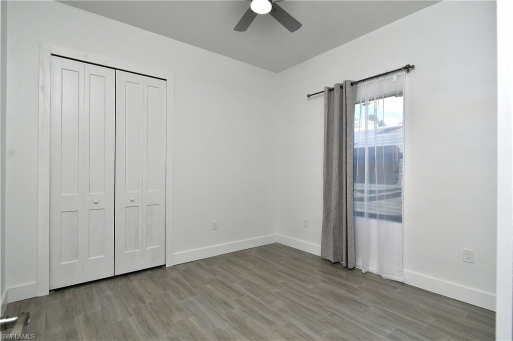 Unfurnished bedroom with ceiling fan, light wood-style flooring, and a closet