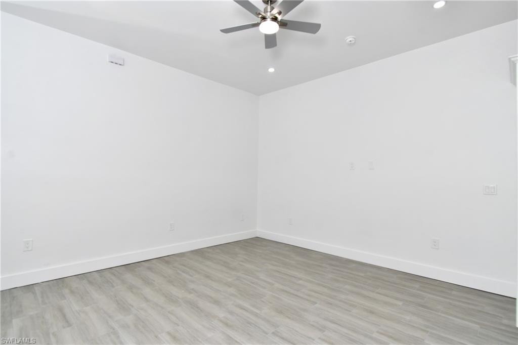 Spare room with light wood-style floors, a ceiling fan, and recessed lighting