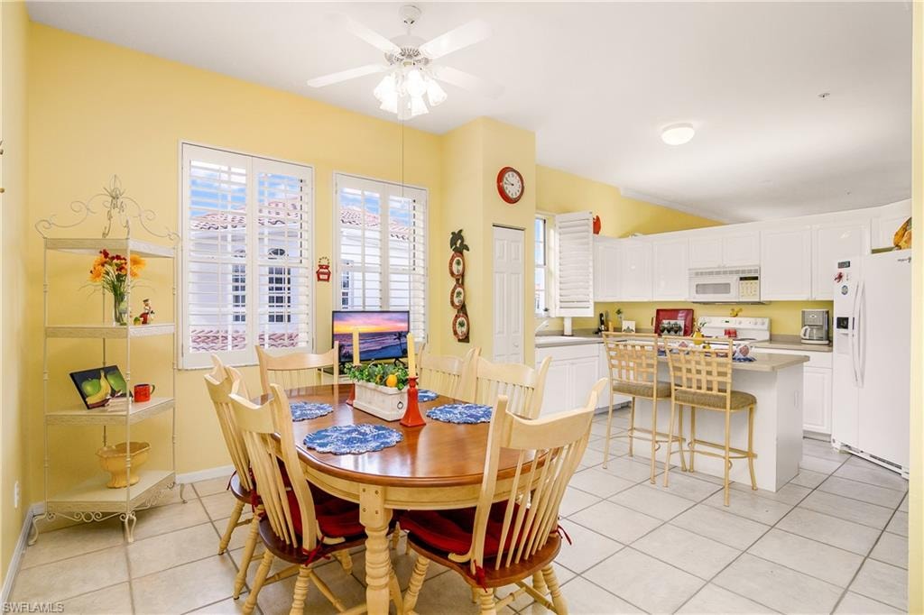 Tiled dining space featuring ceiling fan