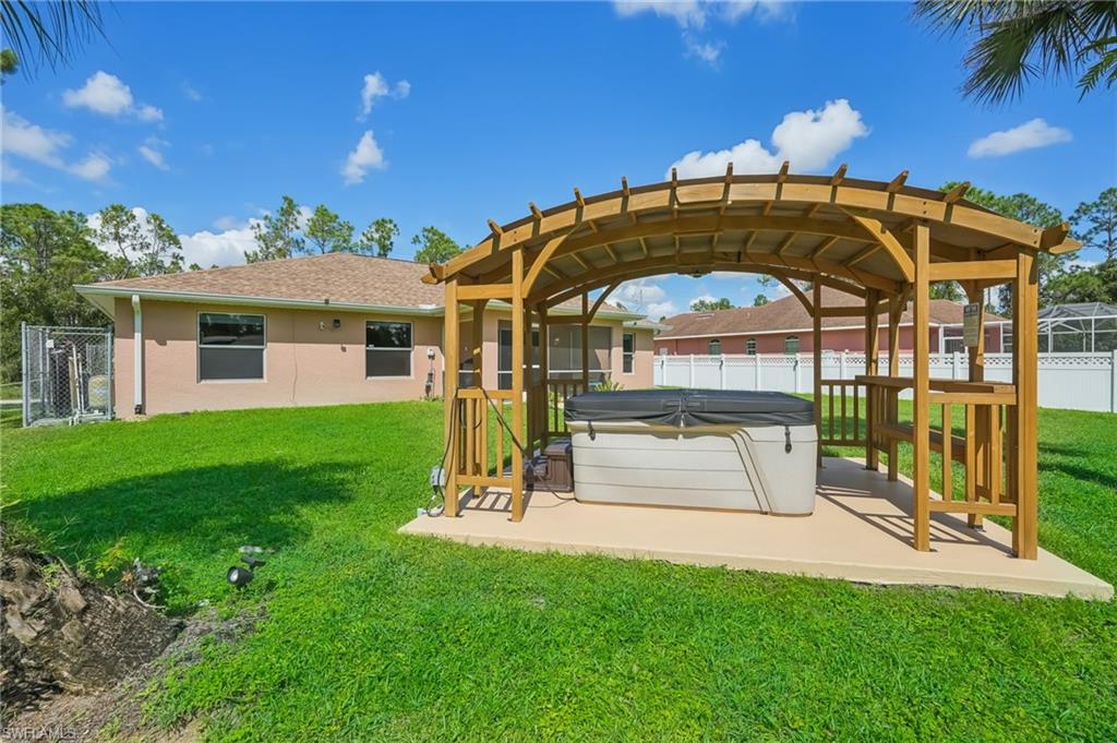 Dock featuring a fenced backyard, a hot tub, and a patio area