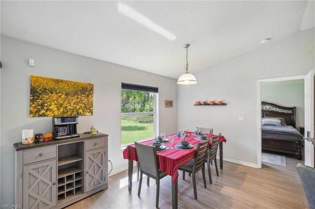 Dining room with vaulted ceiling and light wood-style floors
