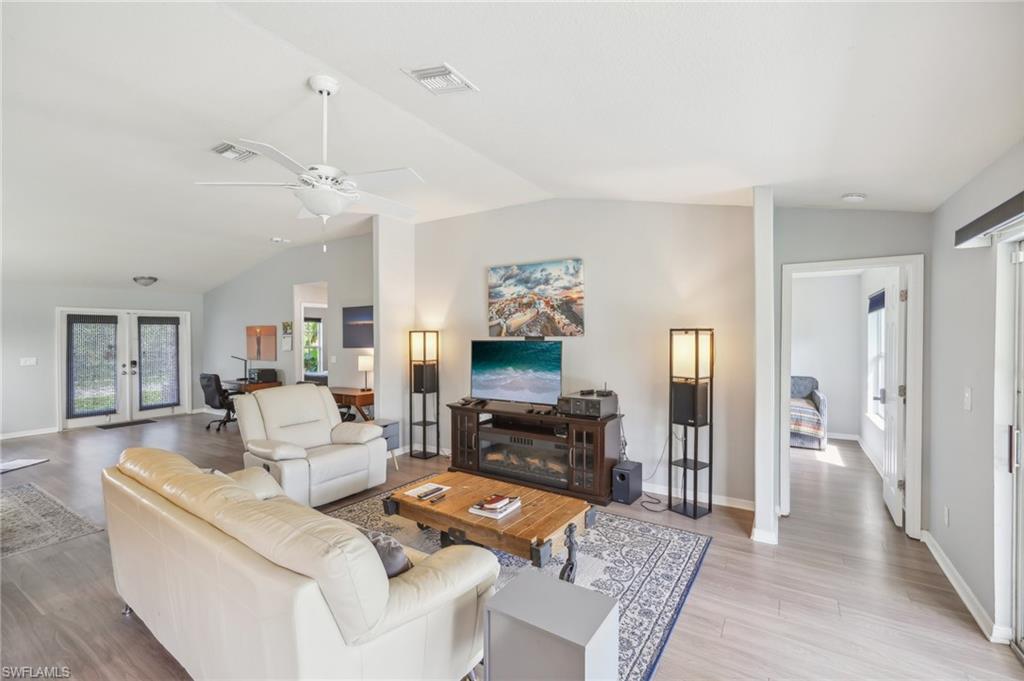 Living area featuring wood finished floors, french doors, a ceiling fan, and an office area