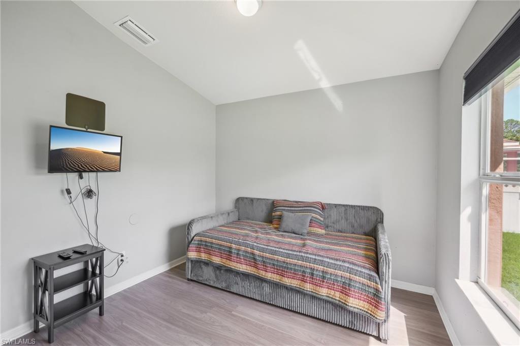 Bedroom featuring wood finished floors and lofted ceiling