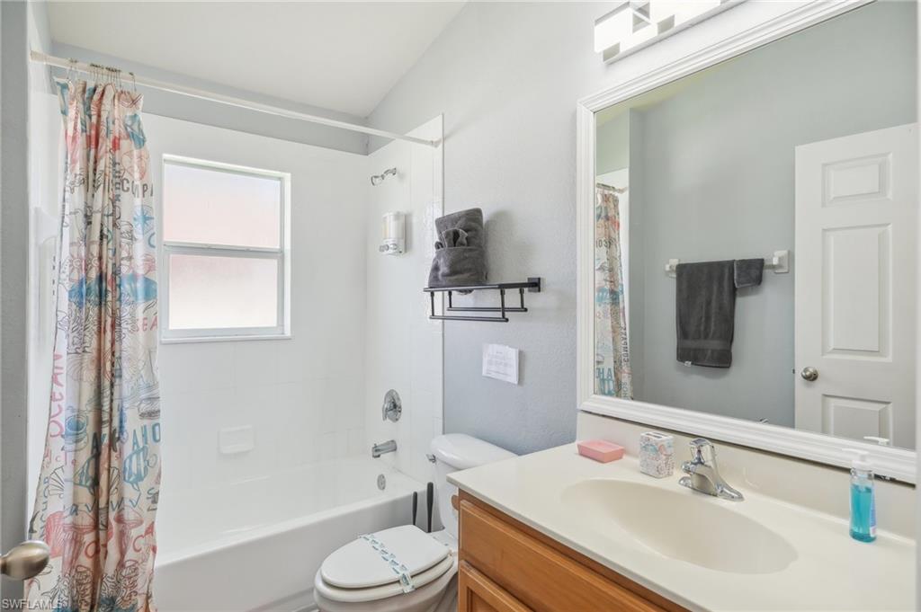 Bathroom featuring shower / tub combo with curtain and vanity