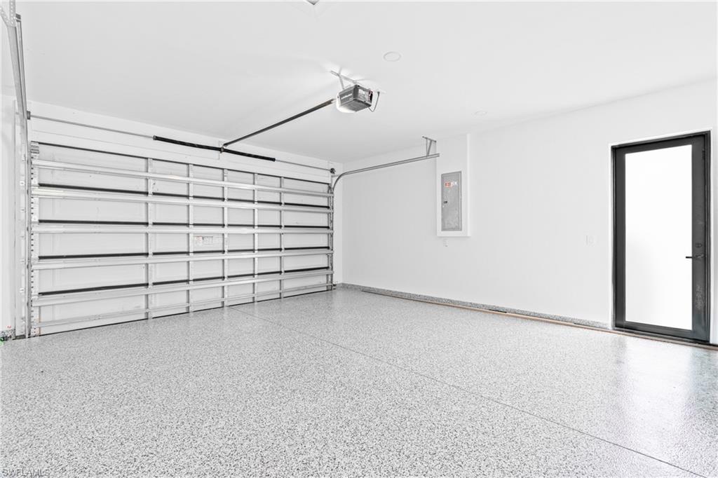 Garage featuring electric panel and a garage door opener