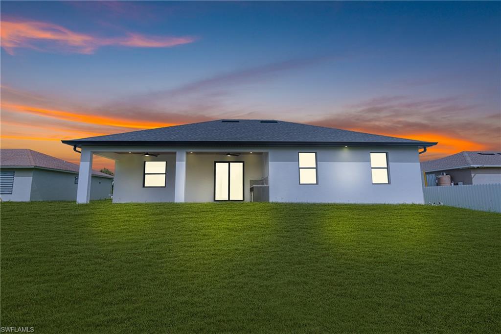 Back of property with a yard, a patio area, and stucco siding