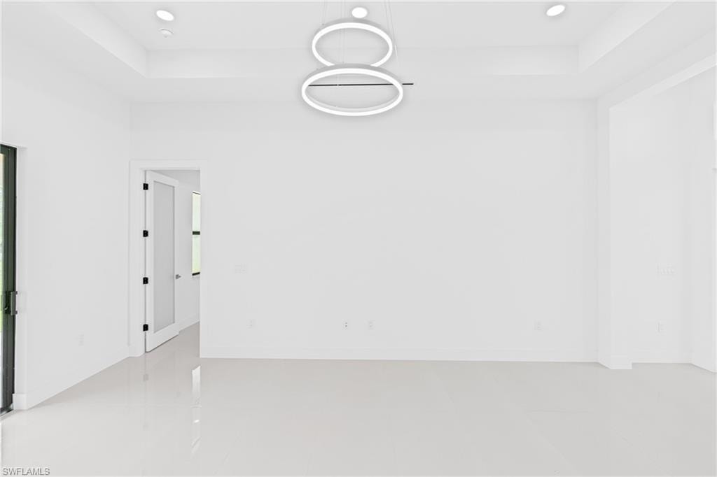 Unfurnished room featuring a tray ceiling and recessed lighting