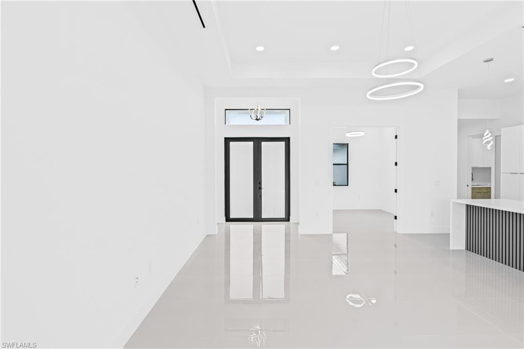 Entryway with recessed lighting and a raised ceiling