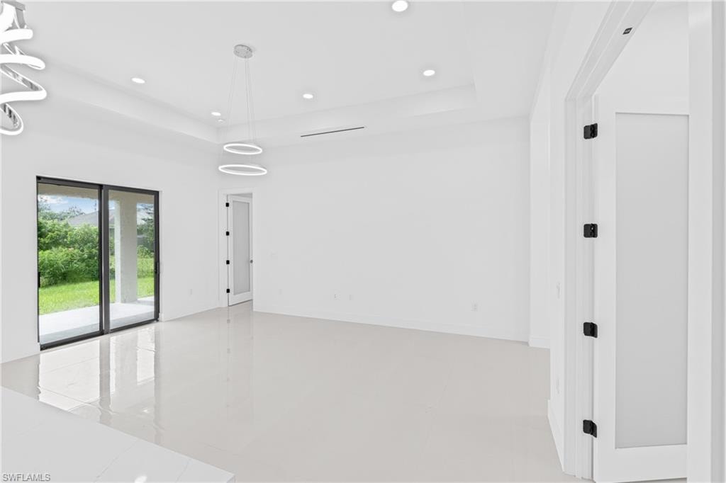 Unfurnished room with a tray ceiling and recessed lighting