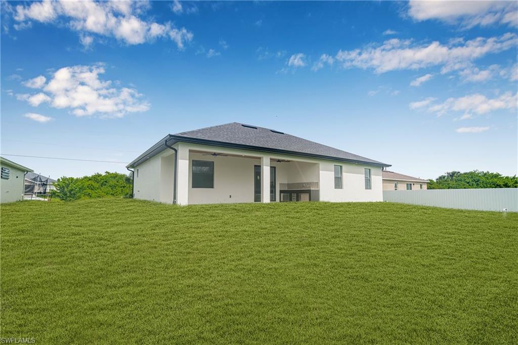 Rear view of house with ceiling fan, a patio area, and stucco siding