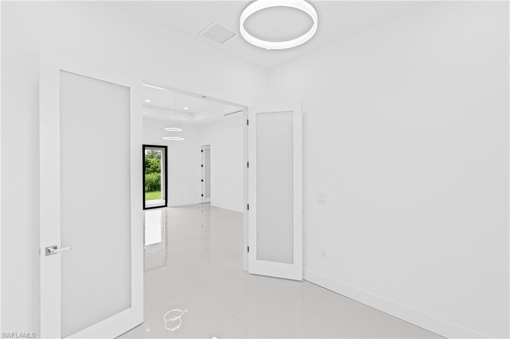 Empty room with finished concrete flooring and baseboards