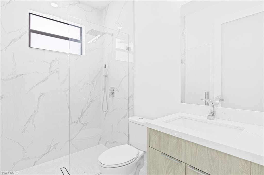 Full bathroom featuring vanity and a marble finish shower