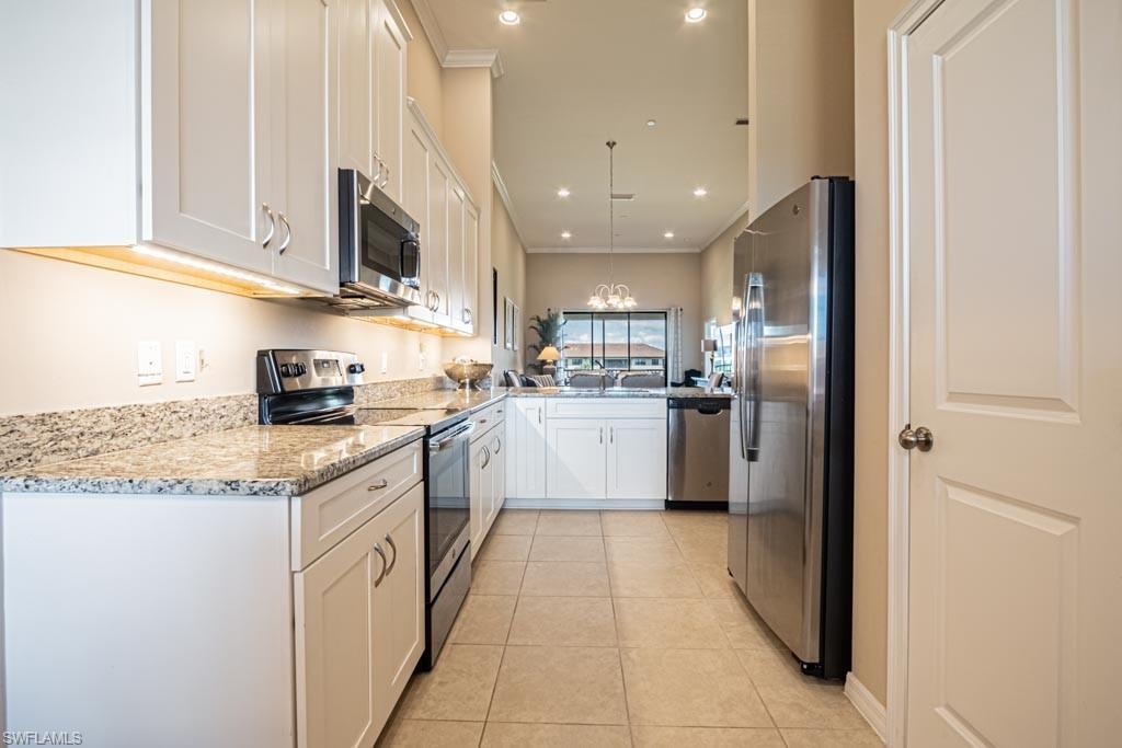 granite counters, stainless steel appliances, ceramic tile flooring, white cabinetry