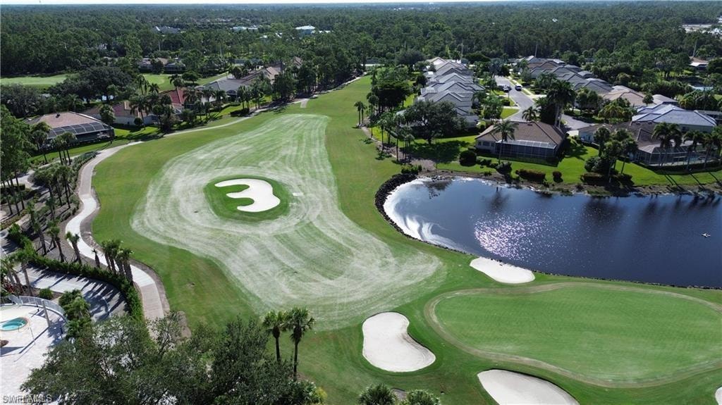 Aerial view of property and surrounding area featuring a golf course and nearby suburban area