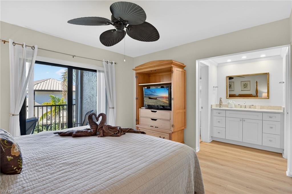 Bedroom with light wood-style flooring, access to balcony, and ceiling fan