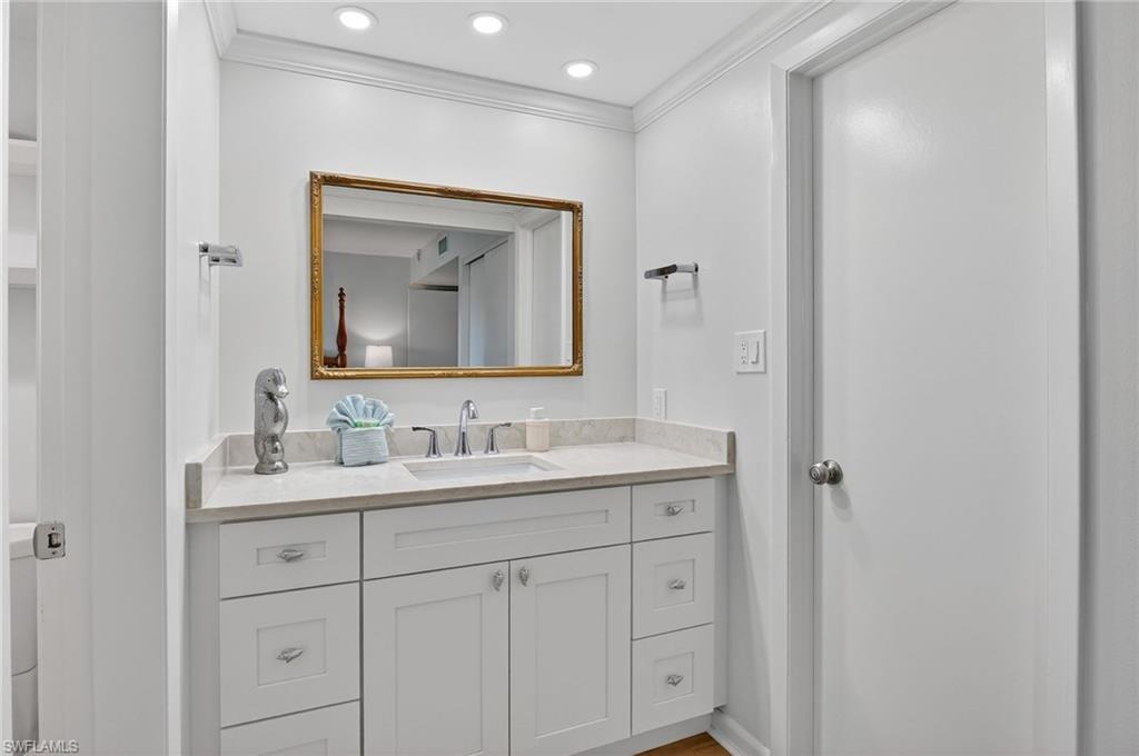 Bathroom with vanity, ornamental molding, and recessed lighting