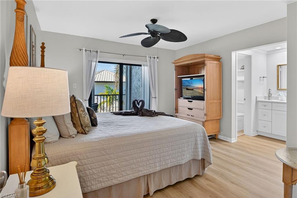 Bedroom with light wood-style floors, access to exterior, ensuite bathroom, and a ceiling fan
