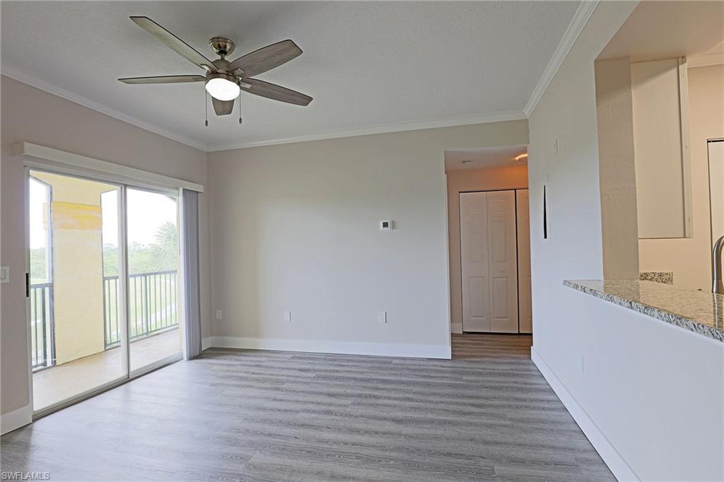 Empty room featuring ornamental molding, light wood finished floors, and a ceiling fan