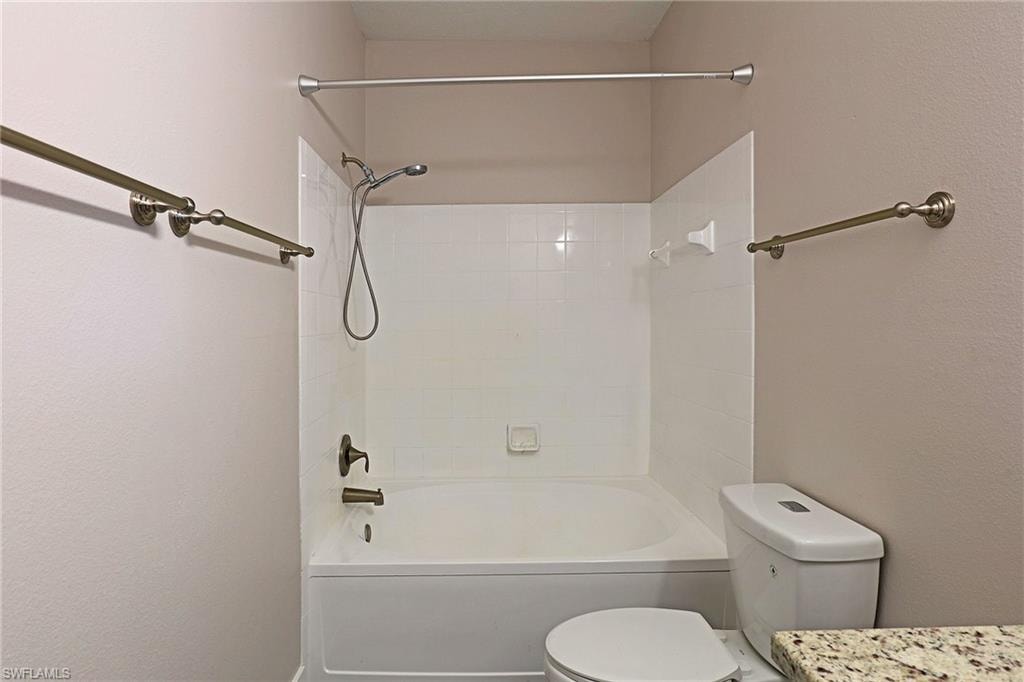 Bathroom featuring bathing tub / shower combination, vanity, and a textured wall