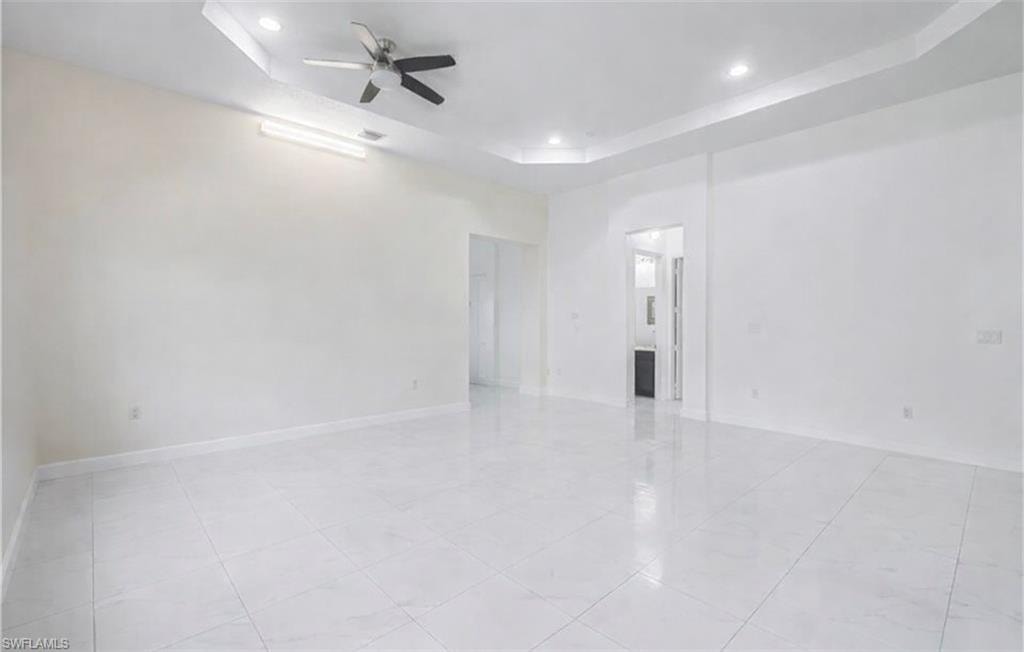 Unfurnished room with a raised ceiling, ceiling fan, and recessed lighting