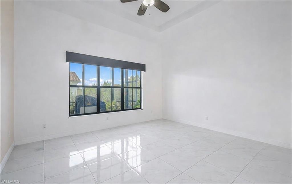 Spare room with a high ceiling and a ceiling fan