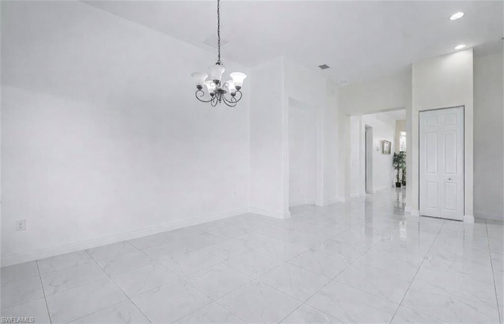 Empty room featuring hanging lights and baseboards