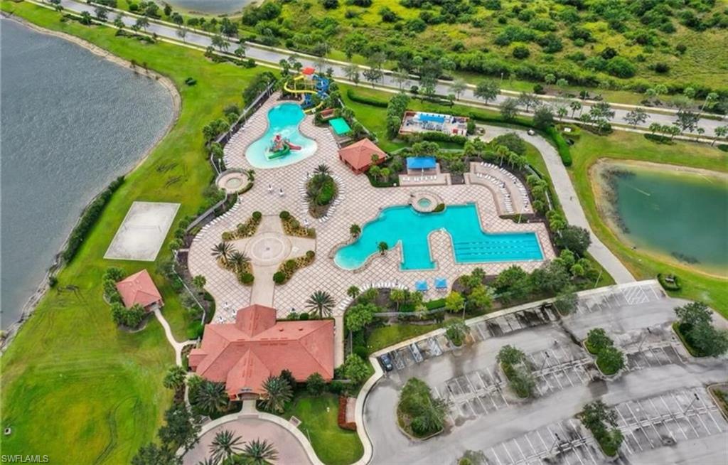 Aerial view of property and surrounding area with a pool area and a nearby body of water