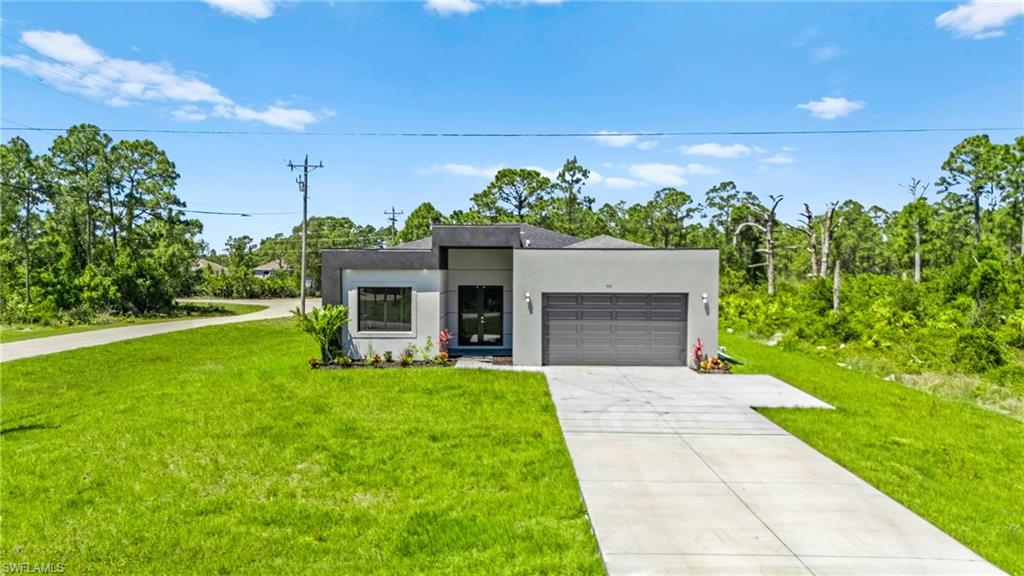 Contemporary house with stucco siding, a front lawn, a garage, and concrete driveway