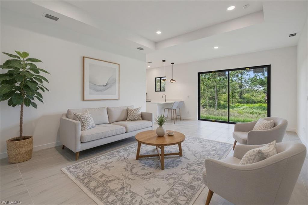 Living room with a tray ceiling and recessed lighting