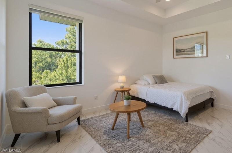 Bedroom featuring a tray ceiling, recessed lighting, ceiling fan, and marble finish floors