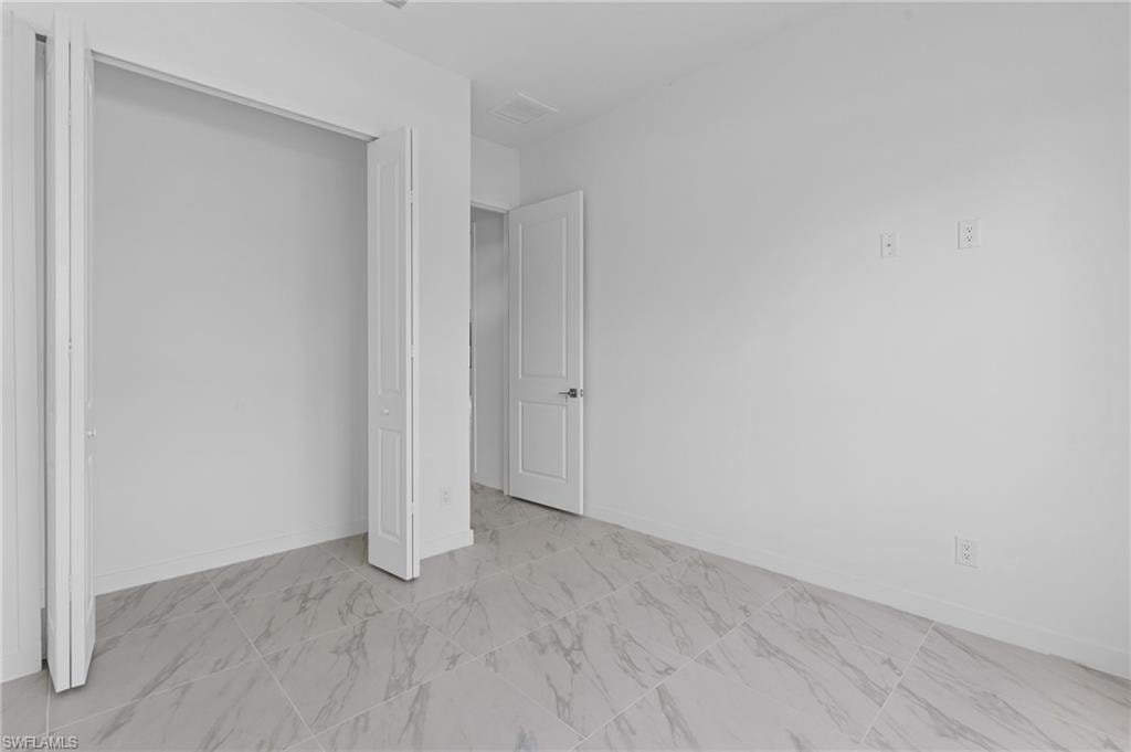 Unfurnished bedroom with baseboards and a closet