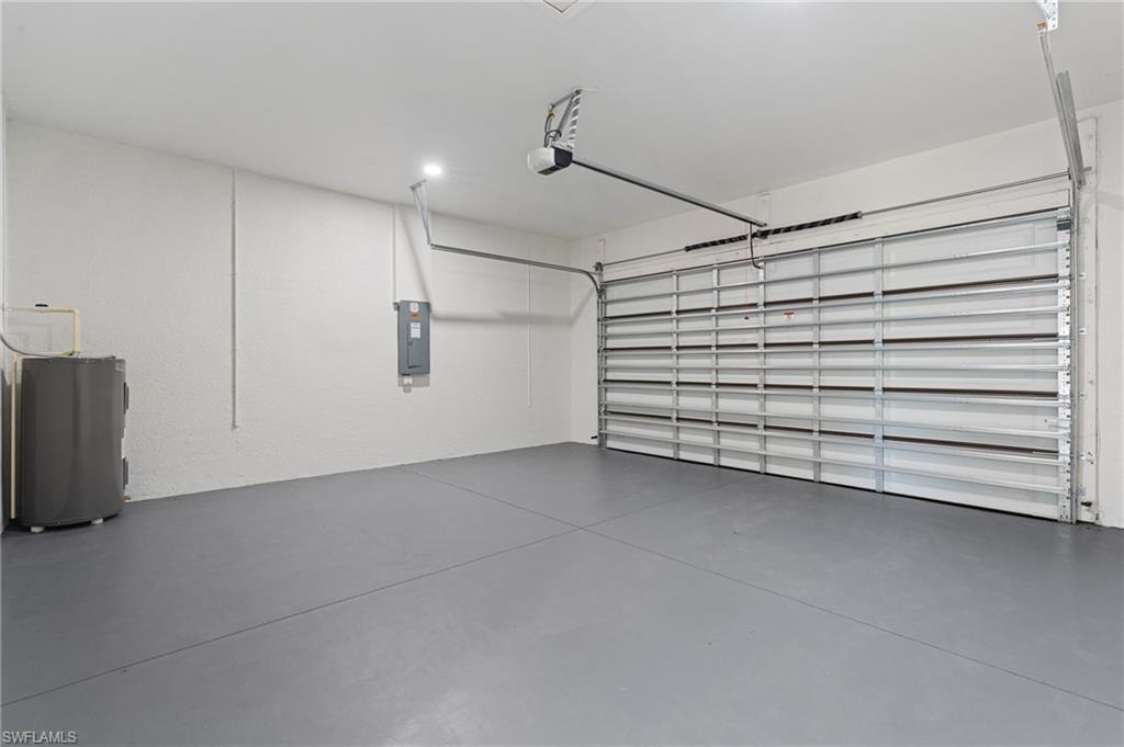 Garage featuring electric panel and water heater
