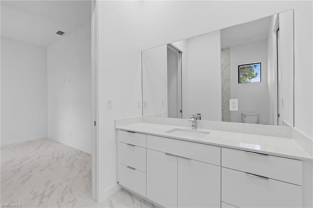 Full bathroom featuring vanity and light marble finish floors