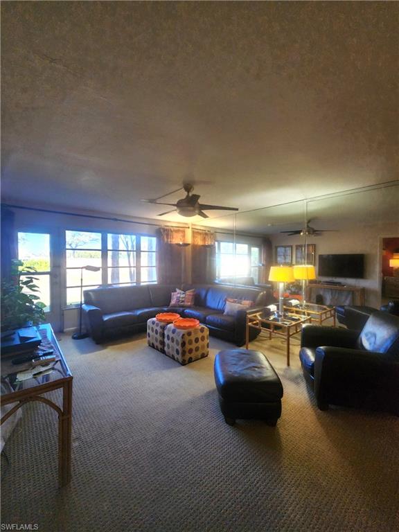 Living area featuring ceiling fan and carpet floors
