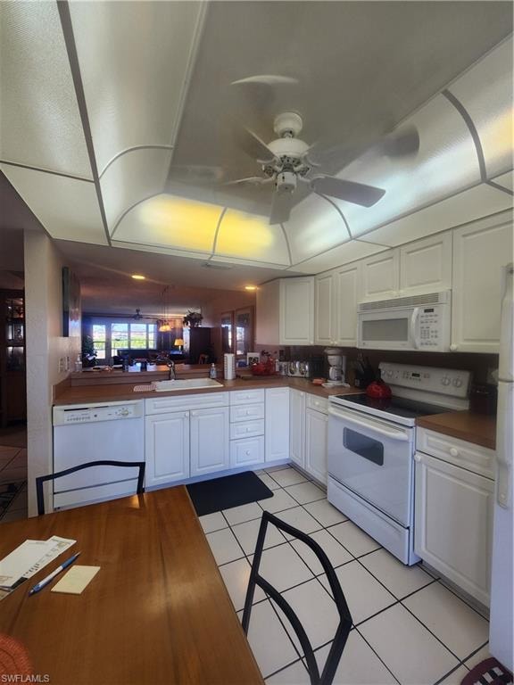 Kitchen featuring white range oven, white cabinets, light tile patterned flooring, and dishwashing machine