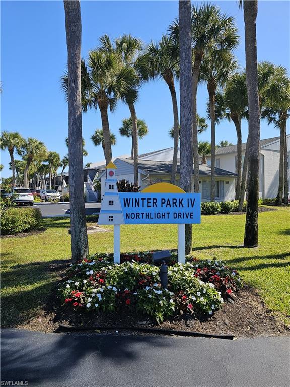 Community / neighborhood sign featuring a yard