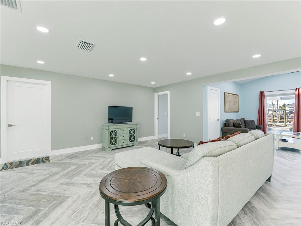 Access to garage and primary bedroom from living space, den area seen the the right