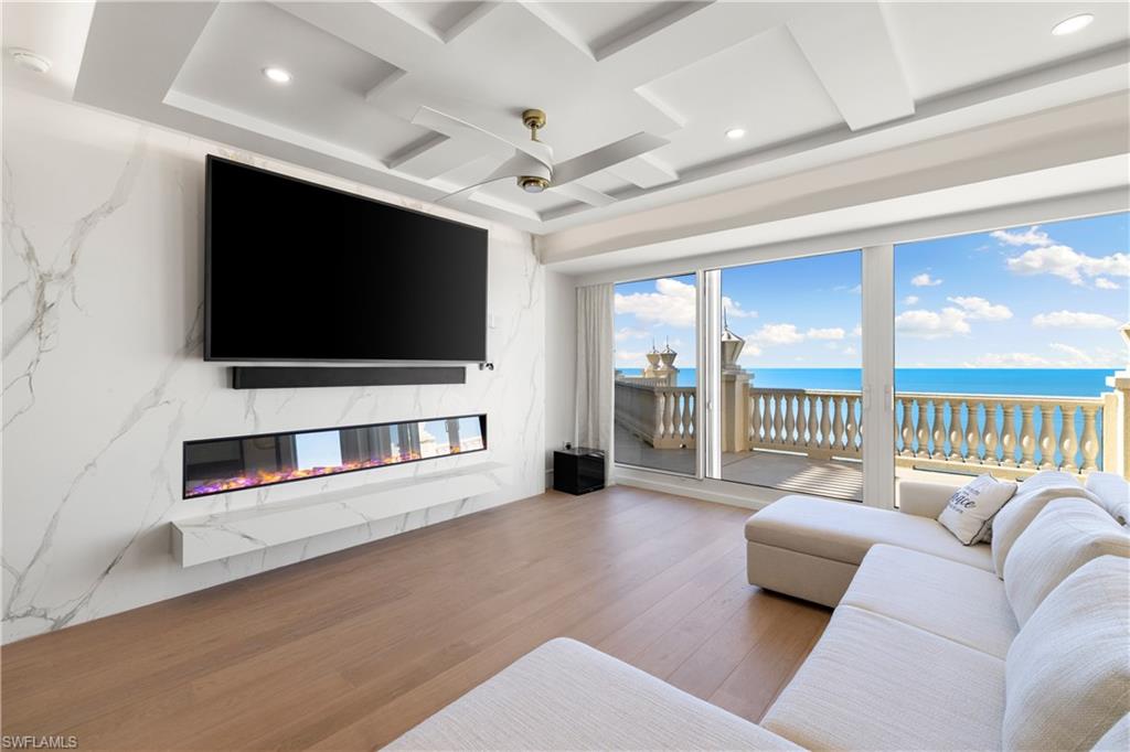 Living area featuring a high end fireplace, wood finished floors, ceiling fan, and recessed lighting