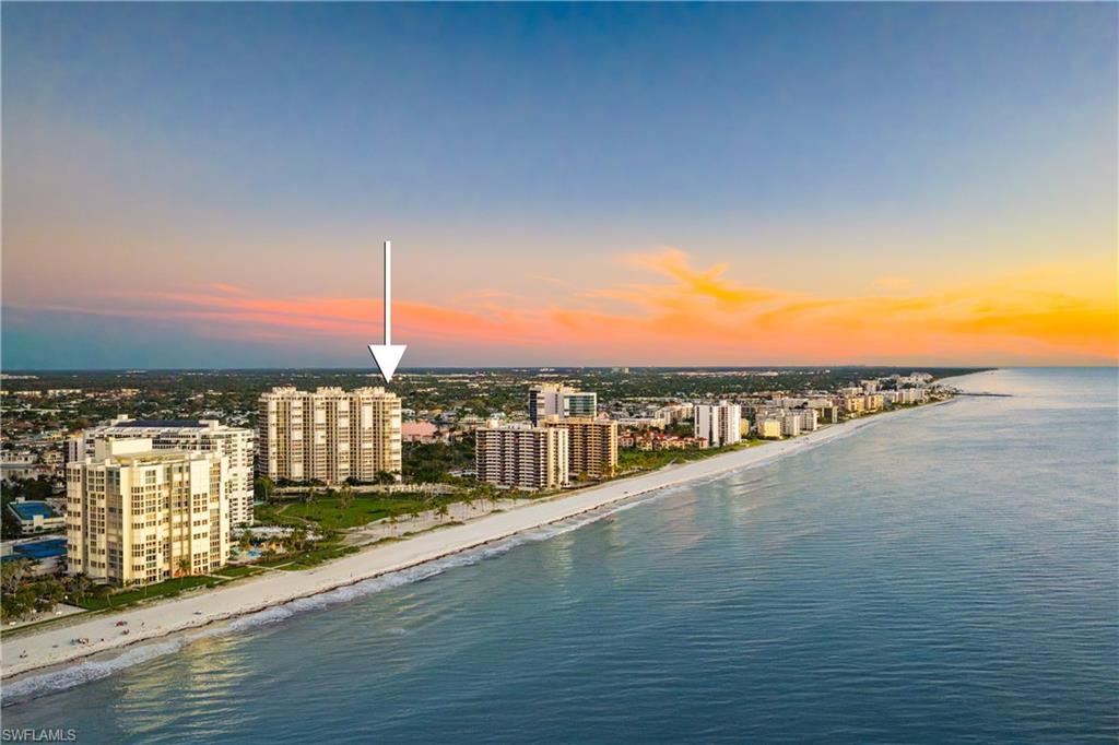Aerial view at dusk of view of water and beach and a view of city