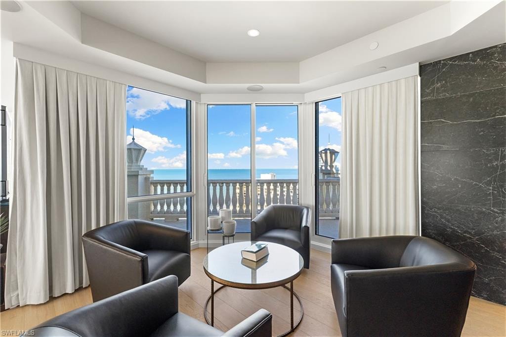 Living area with a water view, light wood-type flooring, plenty of natural light, and recessed lighting