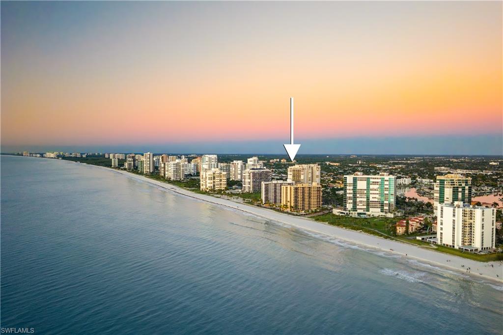 Aerial view at dusk of view of water and beach and a view of city