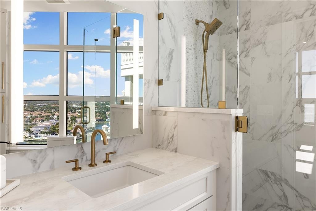 Bathroom view of vanity and a marble finish shower