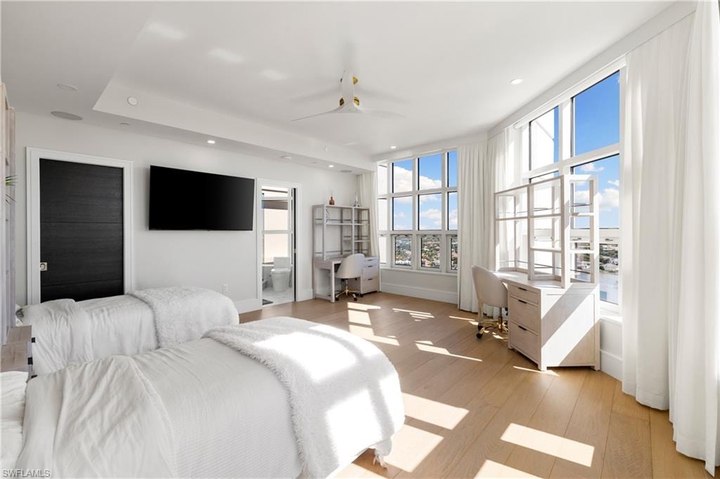 Bedroom with built in desk, recessed lighting, light wood-style flooring, and ensuite bath