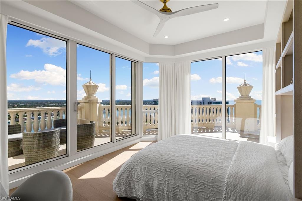 Bedroom featuring wood finished floors, a ceiling fan, a water view, access to outside, and recessed lighting