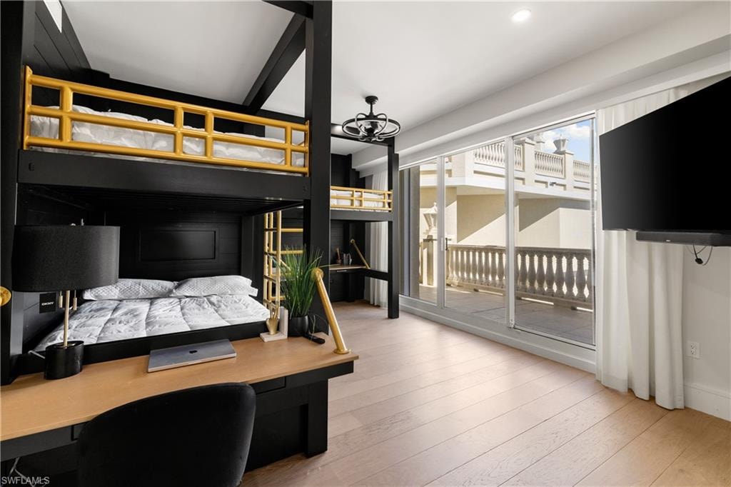 Bedroom featuring light wood-style floors, a desk, and access to outside