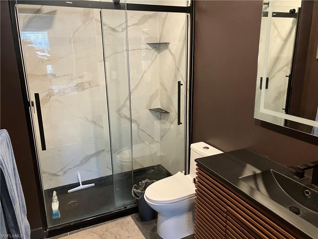 Full bathroom with a marble finish shower and vanity